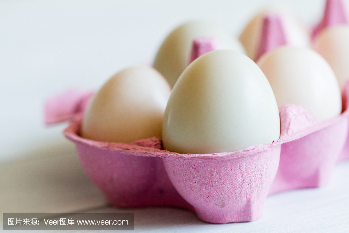混合鸭蛋在粉红色的蛋盒